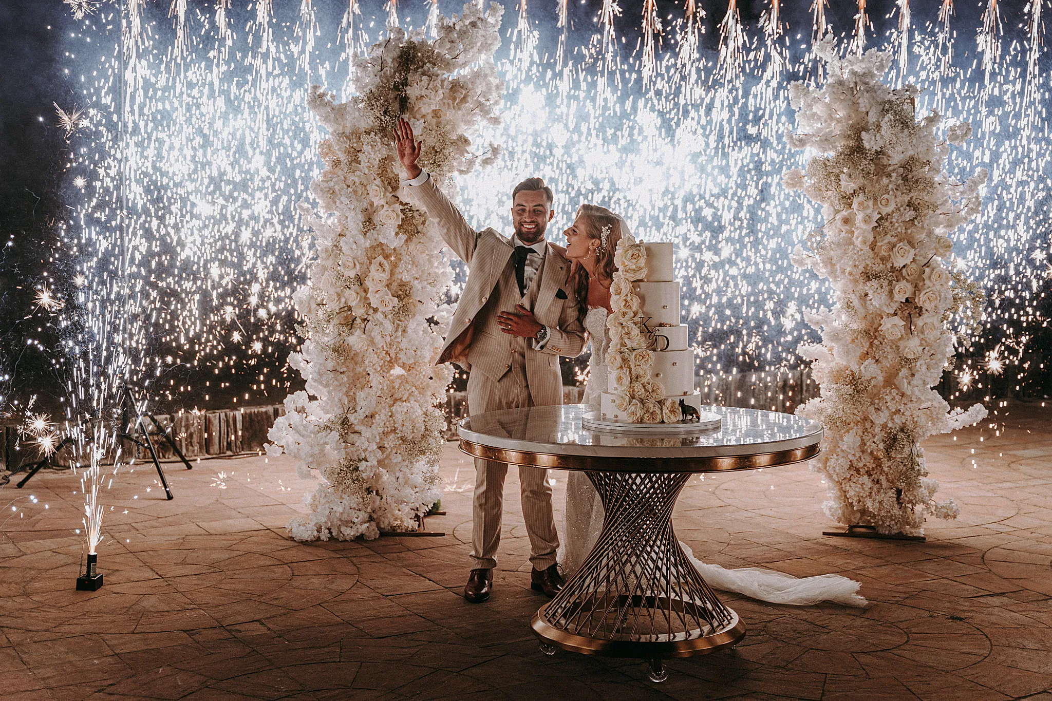 Efektowne krojenie tortu weselnego nad brzegiem jeziora w Hotelu Bajka w otoczeniu fontann iskier i fajerwerków